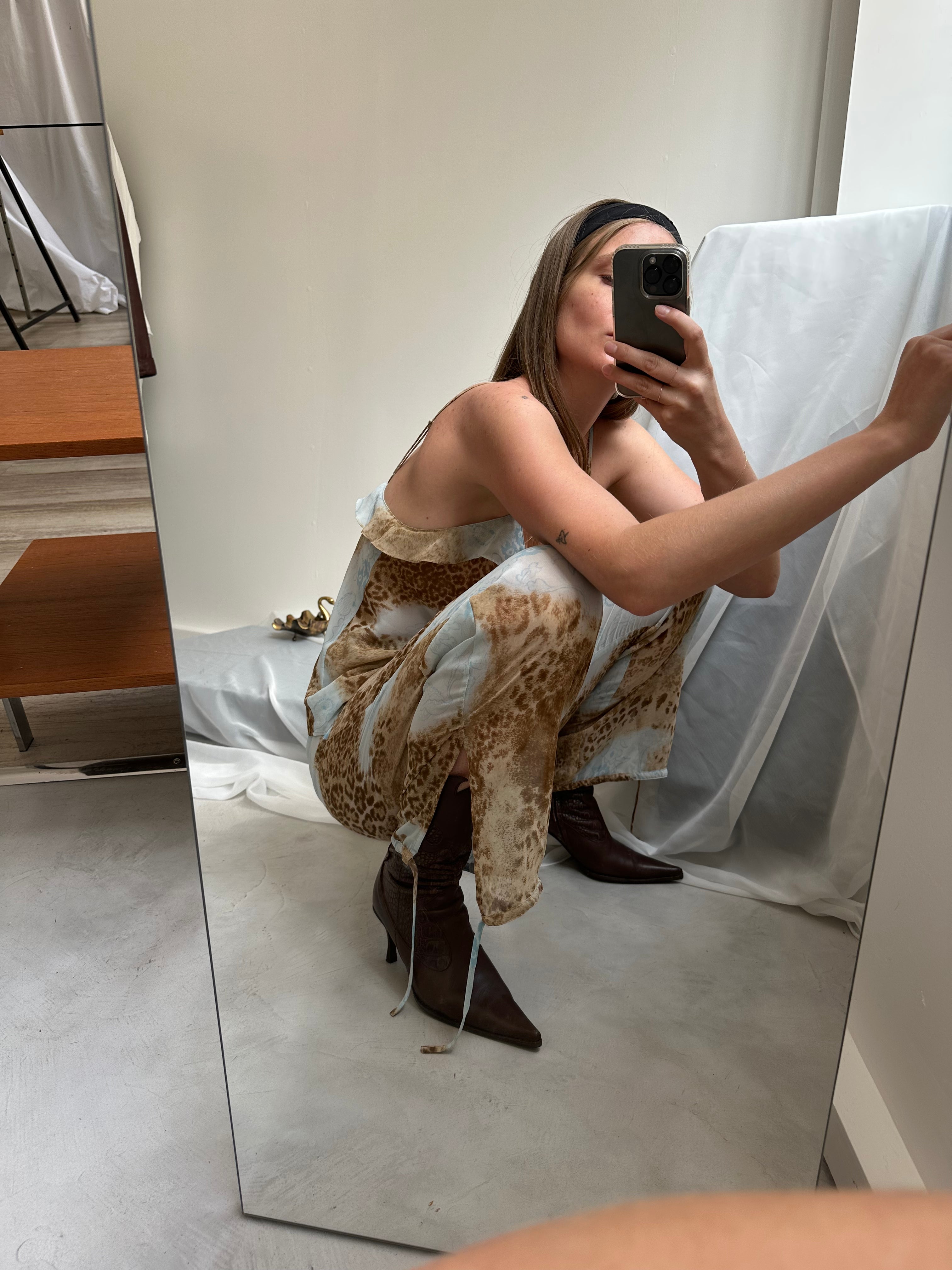 Un mannequin prend une photo de l'ensemble deux pièces vintage qu'elle porte.